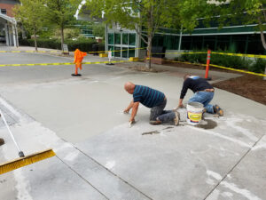 Crew finishing a concrete surface outside a commercial building