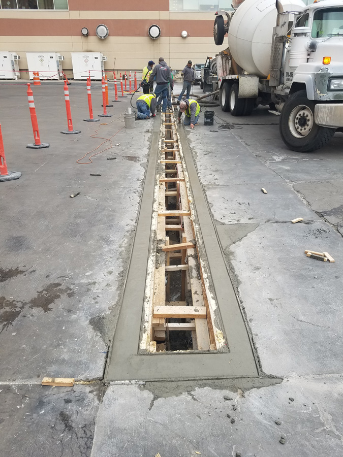 Concrete delivery truck beside prepared linear formwork