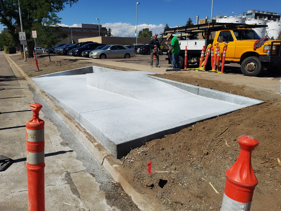 New concrete slab bordered by safety cones at a work site