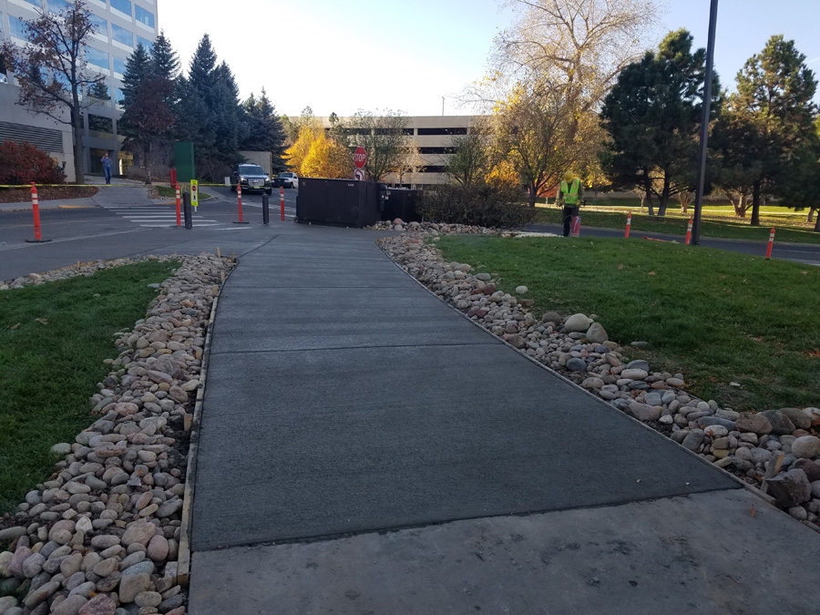 Concrete walkway with rock borders across commercial grounds