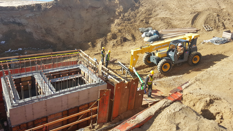 Concrete wall formwork and construction equipment on a commercial site