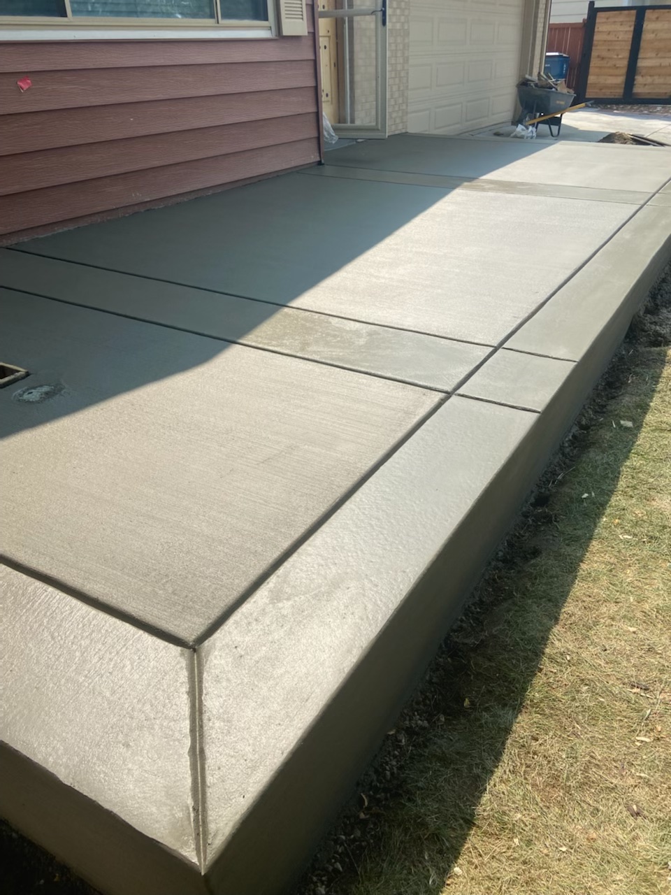 Straight concrete path alongside a home exterior