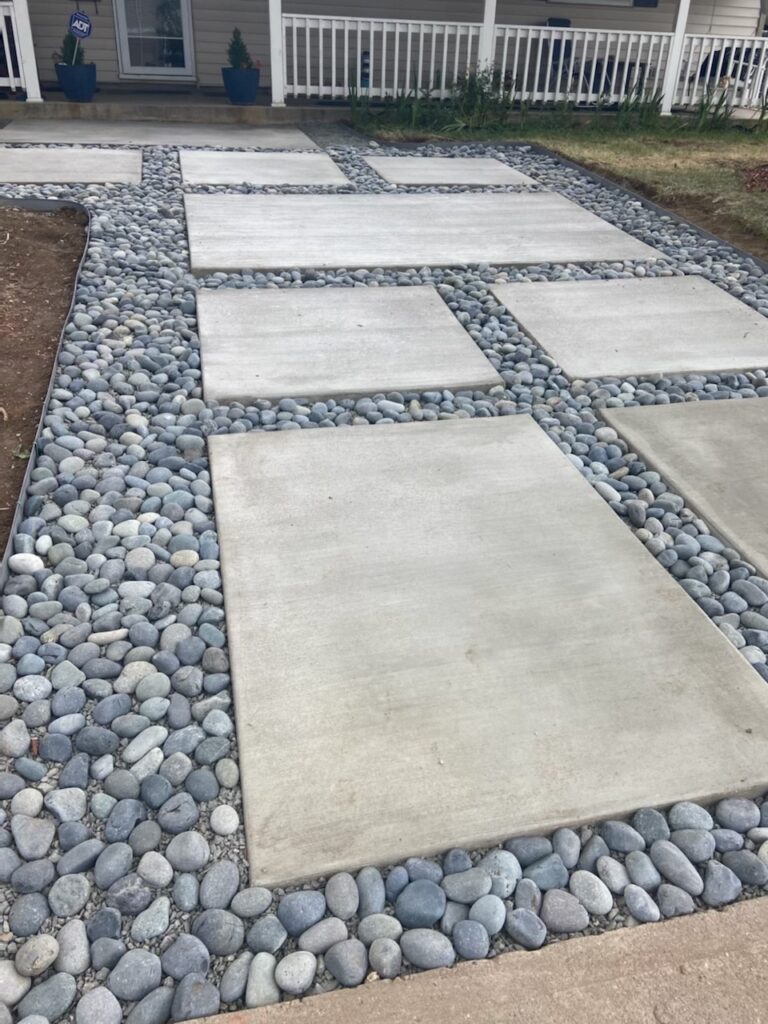 Rectangular concrete walkway sections separated by decorative stone